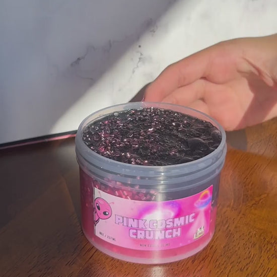 Video of Pink Cosmic Crunch pink clear bingsu bead slime with a metallic black topping being stretched and crunched