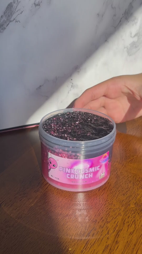 Video of Pink Cosmic Crunch pink clear bingsu bead slime with a metallic black topping being stretched and crunched