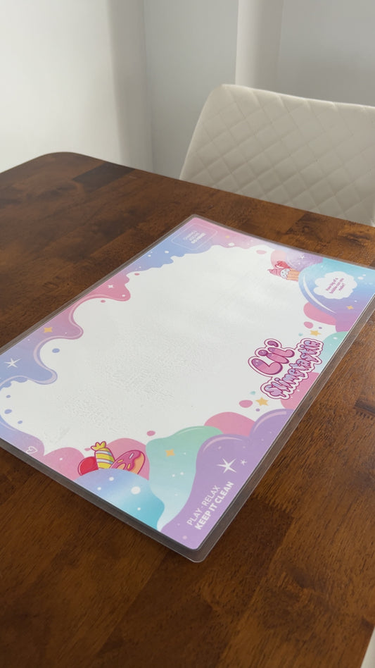 Lil' Slimetastic slime play mat with pink and purple border on a wooden table
