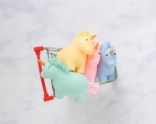 Yellow, pink, blue and mint unicorn squishy stress balls in a mini shopping cart